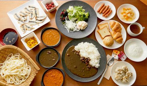 a table topped with plates of food and bowls of food at Centurion Hotel & Spa Kurashiki Station in Kurashiki