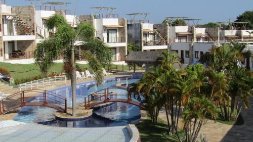 a swimming pool with a bridge and palm trees at Brisas do Amor 131 in Pipa