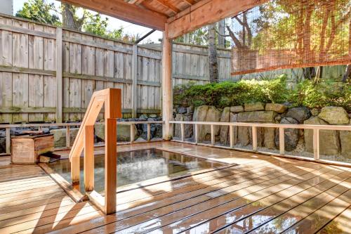 a wooden deck with a pond and a fence at Yanagi No Yu in Aomori