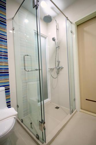 a glass shower in a bathroom with a toilet at S3 Residence Park in Bangkok