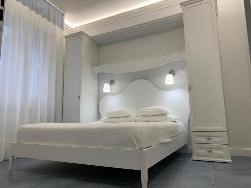 Dormitorio blanco con cama blanca y espejo en CASA CAMILLA en Chioggia