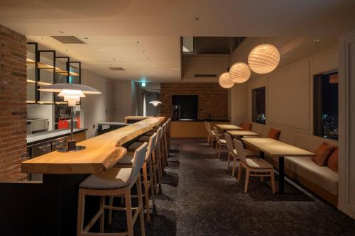 a row of tables and chairs in a restaurant at Tokyu Stay Hakodate Asaichi Akarinoyu in Hakodate