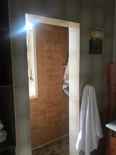 a bathroom with a shower with a white towel at Casa com charme de montanha em Itaipava! in Petrópolis