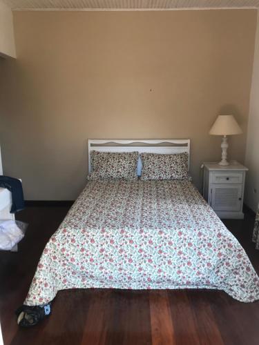 a bedroom with a bed with a floral bedspread at Casa com charme de montanha em Itaipava! in Petrópolis