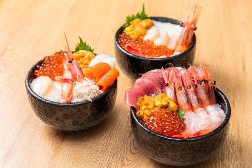 three bowls of food on a wooden table at Tokyu Stay Hakodate Asaichi Akarinoyu in Hakodate