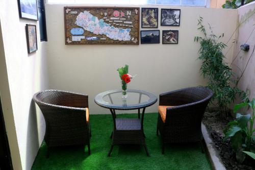 a table with two chairs and a table with a vase on it at Hotel Family Ties Pvt. Ltd. in Kathmandu