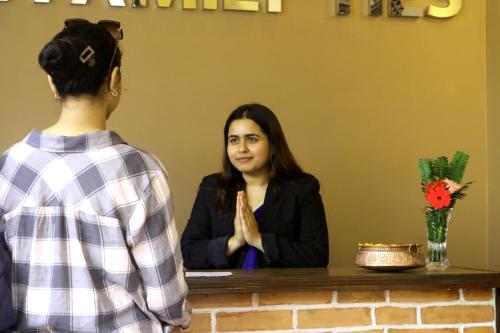 a woman sitting at a counter talking to a girl at Hotel Family Ties Pvt. Ltd. in Kathmandu