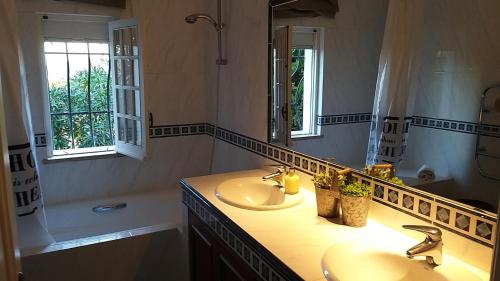 uma casa de banho com 2 lavatórios e um espelho grande em Fabulosa Quinta do Vento em Palmela