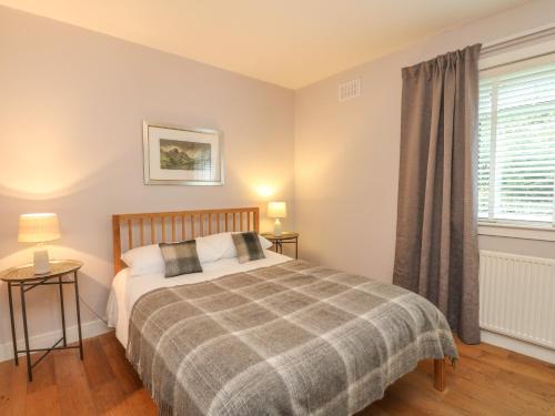 a bedroom with a bed and a window at Holly Cottage in Glencoe