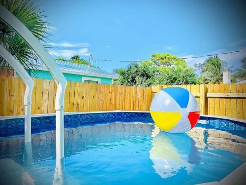 a colorful beach ball sitting in a swimming pool at Cute Tiny House w Private Plunge Pool near Beach in Delray Beach