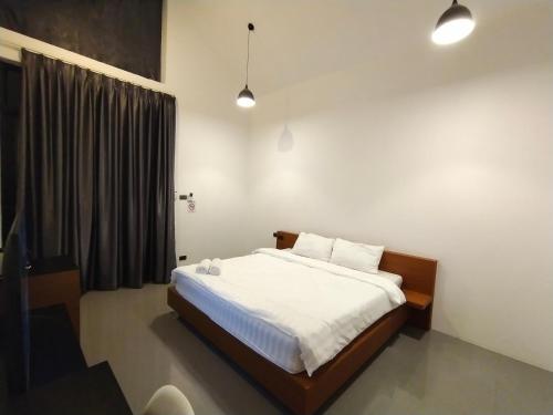 una camera da letto con un letto con lenzuola bianche e una finestra di ATTITUDE THE RESORT a Nakhon Ratchasima