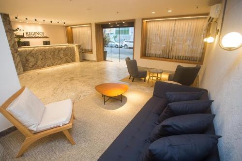 a living room with a blue couch and chairs at Regency Copacabana Hotel in Rio de Janeiro