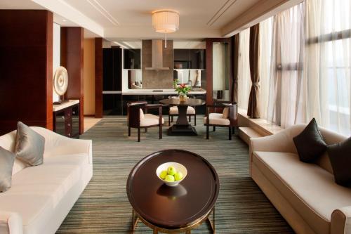 a living room with a couch and a table at Radisson Blu Plaza Chongqing - Free one cup of smoky the gelnlivet during stay in Chongqing