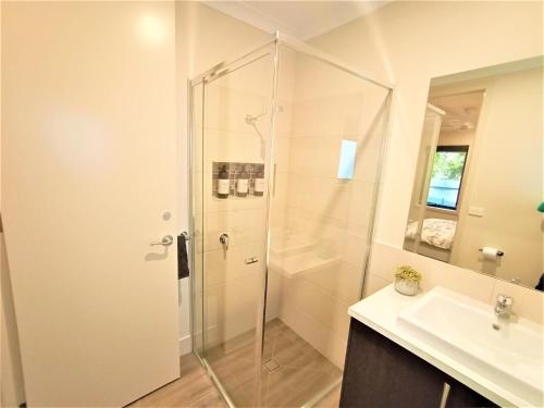 La salle de bains est pourvue d'une douche et d'un lavabo. dans l'établissement My Place in Albury, à Albury