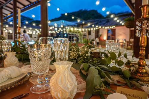 a table with wine glasses and flowers on it at Don Juan De Dios De Guane Hotel & Centro De Convenciones in Barichara