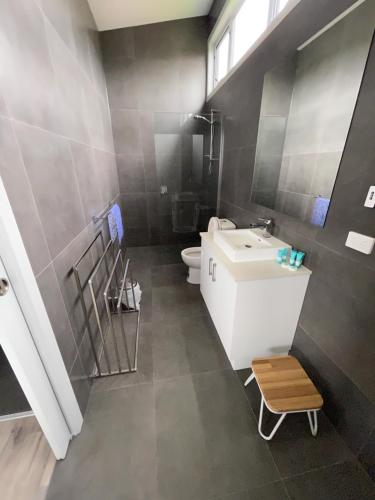 a bathroom with a white sink and a toilet at Creek to Beach in Apollo Bay