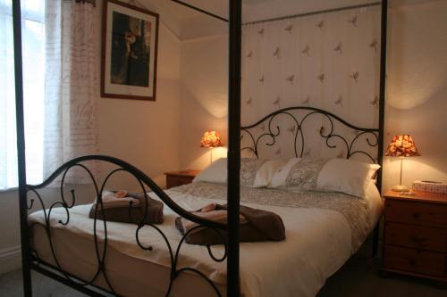 a bedroom with a bed with a wrought iron bed frame at The Haldon Guest House in Paignton