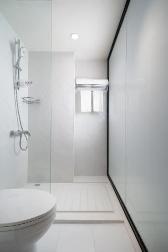 a white bathroom with a shower and a toilet at 有集城市客栈锦绣中华店Unijoy Cityinn Splendid China Shenzhen in Shenzhen