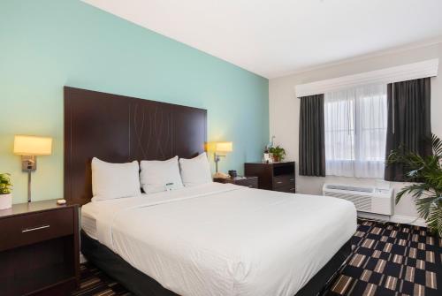 a hotel room with a large bed with white sheets at The Hotel Oceanside in Oceanside
