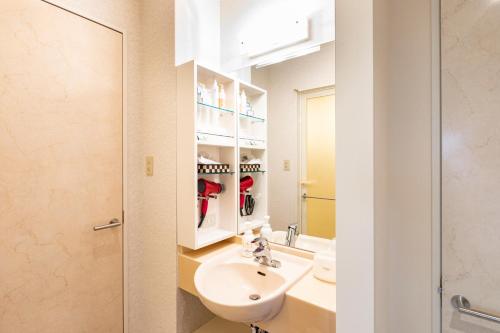a bathroom with a sink and a mirror at Hotel Vega Takamatsu (Adult Only) in Takamatsu