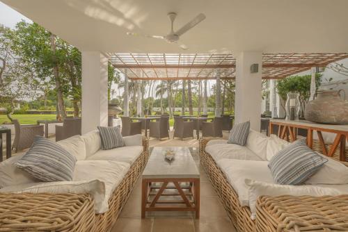 a living room with wicker couches and a table at The Villa Bentota by KK Collection in Bentota