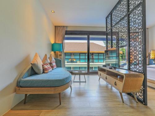 a living room with a blue couch and a desk at AKIRA Lipe Resort in Ko Lipe