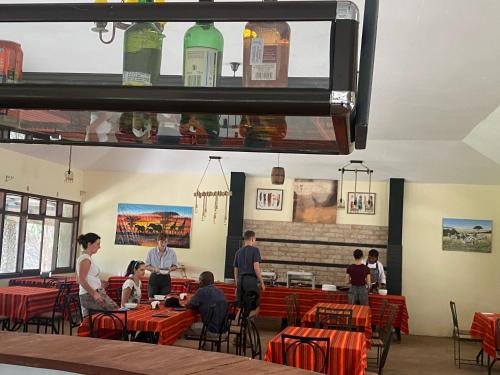 a group of people sitting at tables in a restaurant at Oldarpoi Wageni Camps in Keekorok