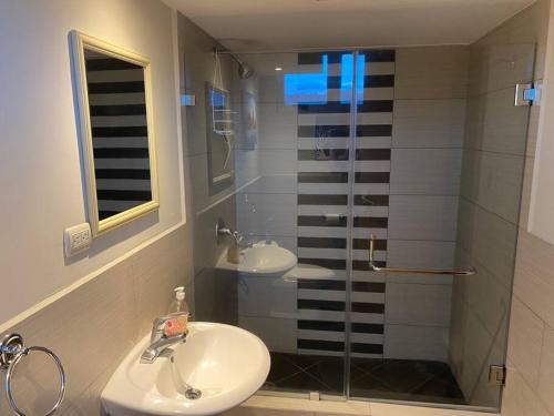 baño con lavabo y ducha con puerta de cristal en 2 Rooms, 1 King Size bed, 64" Smart HDTV, en Guatemala