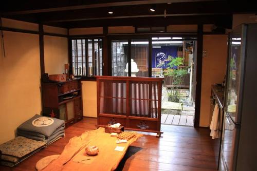 a room with a living room with a table and a room with a window at Onoan in Hida