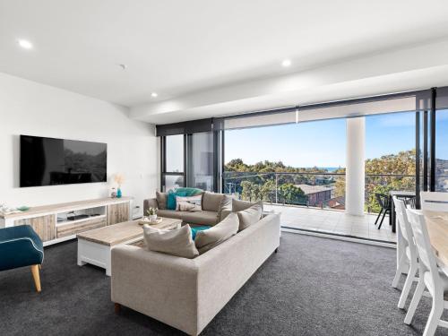 a living room with a couch and a large window at Cove 401 in Forster