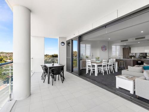 an open living room and dining room with a table and chairs at Cove 401 in Forster