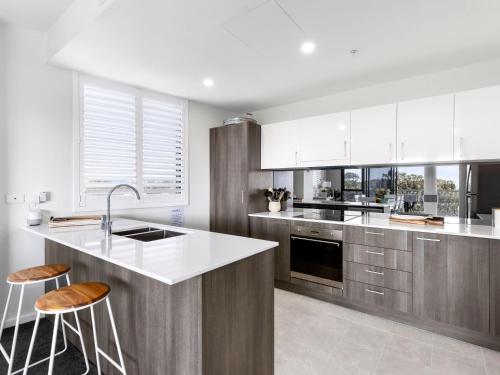 a kitchen with white cabinets and a white counter top at Cove 401 in Forster