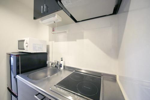 a small kitchen with a sink and a microwave at NorthRiverSKY in Tokyo