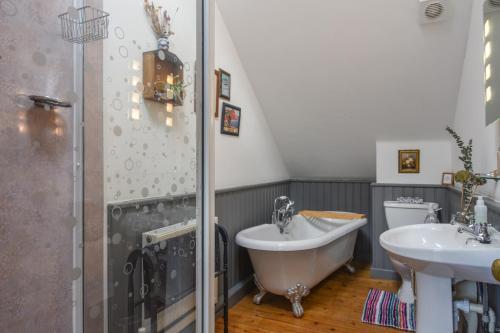ein Badezimmer mit einer Badewanne, einem Waschbecken und einem WC in der Unterkunft The Linhay in Lydford