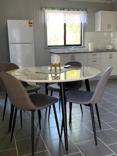 a kitchen with a table and chairs and a refrigerator at Corroboree Park Tavern in Marrakai