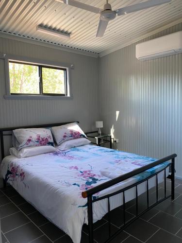 sypialnia z łóżkiem i oknem w obiekcie Corroboree Park Tavern w mieście Marrakai