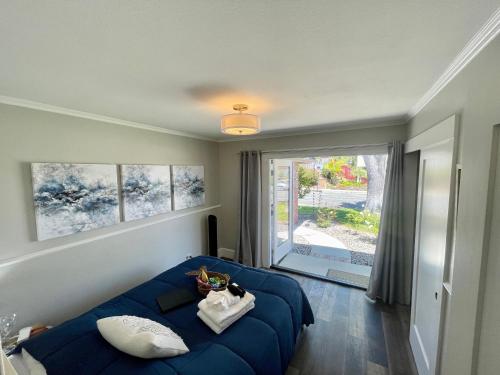 a bedroom with a blue bed and a large window at Lovely Del Mar retreat private entrance 1 bd 1ba in San Diego