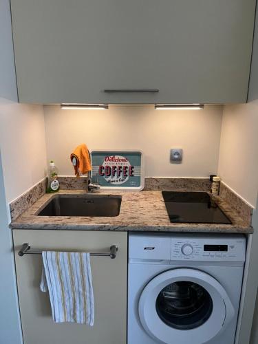 une cuisine avec un évier et une machine à laver dans l'établissement Location appartement cabourg 4 pers, à Cabourg
