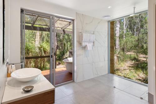 a bathroom with a tub and a sink and a toilet at Hidden Valley Forest Retreat in Carbunup