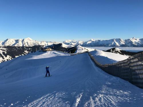 a person is skiing down a snow covered mountain at Das Hexenhäusl in Schmitten