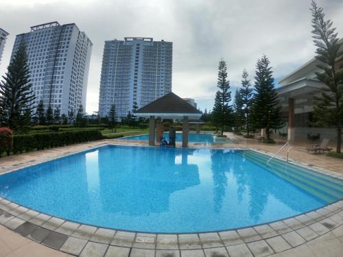 a large blue pool with buildings in the background at Breezy Nest Staycation at Wind Residences Tagaytay in Tagaytay