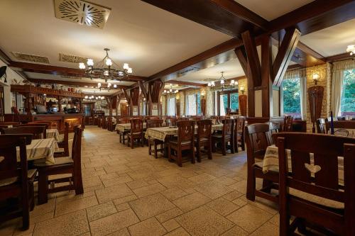 a dining room with tables and chairs in a restaurant at Tercia Hubertus Panzió in Sopron