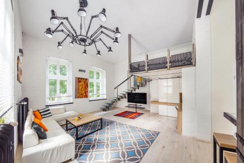 a living room with a couch and a chandelier at Victoria Residence by Baltica Apartments in Sopot