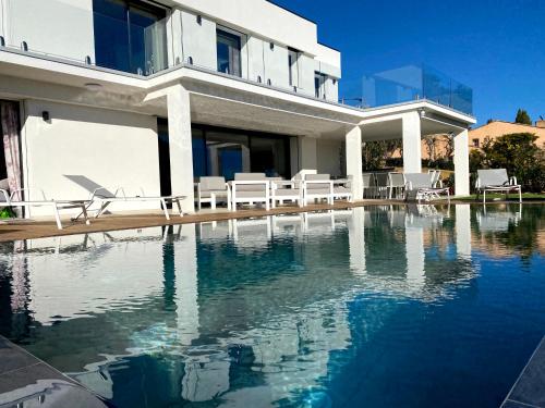 une maison avec une piscine devant une maison dans l'établissement VILLA BLANCHE, à Cavalaire-sur-Mer