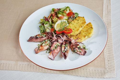 a plate of food with meat and a salad at Tercia Kópháza Panzió B in Kópháza