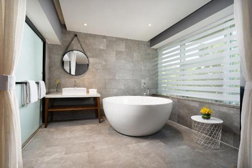 a bathroom with a large tub and a sink at 有集城市客栈锦绣中华店Unijoy Cityinn Splendid China Shenzhen in Shenzhen