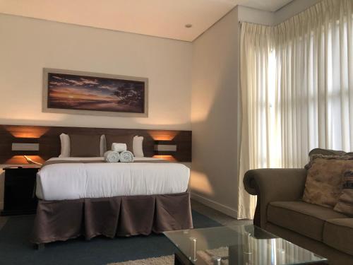a hotel room with a bed and a couch at Seacliff Suites Hotel and Resort in Pinamalayan