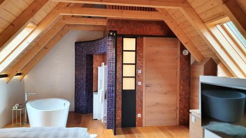 a attic bathroom with a tub and a sink at Living & Relax Resorts in Sausal