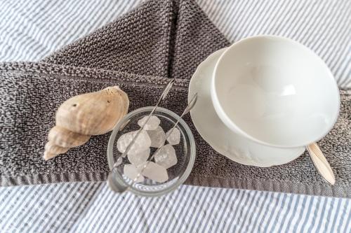 a cup and a container of rocks and a seashell at Strandbude Borkum in Borkum