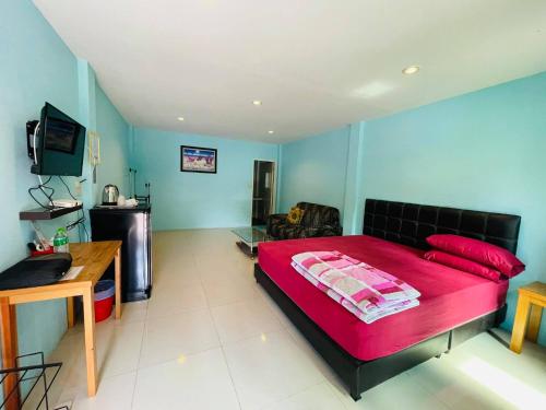 1 dormitorio con 1 cama grande de color rojo y TV en Baan Sri Family, en Kabin Buri